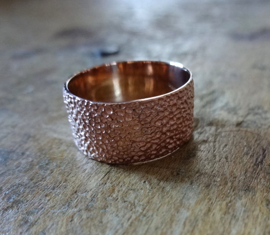 Simple elegant broad ring bands hand textured to emulate the dappled light naturally found in nature handmade in NYC by designer Jayne Moore model Jayne Moore from recycled refined metals in 18kt gold a light classic timeless wedding band for him or for her 