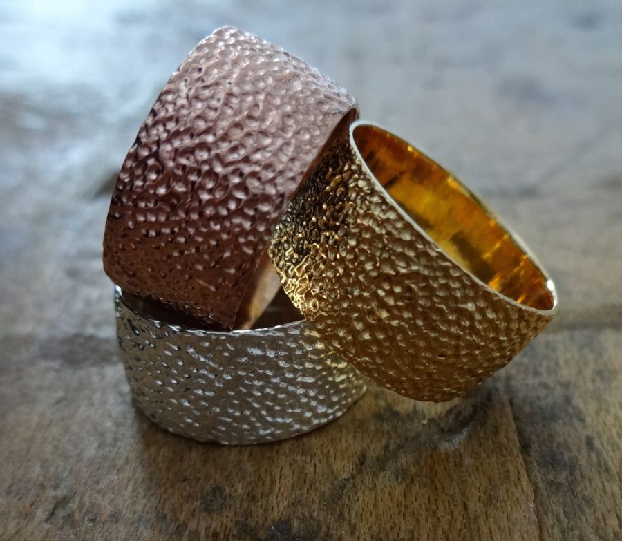 Simple elegant broad ring bands hand textured to emulate the dappled light naturally found in nature handmade in NYC by designer Jayne Moore model Jayne Moore from recycled refined metals in 18kt gold a light classic timeless wedding band for him or for her 