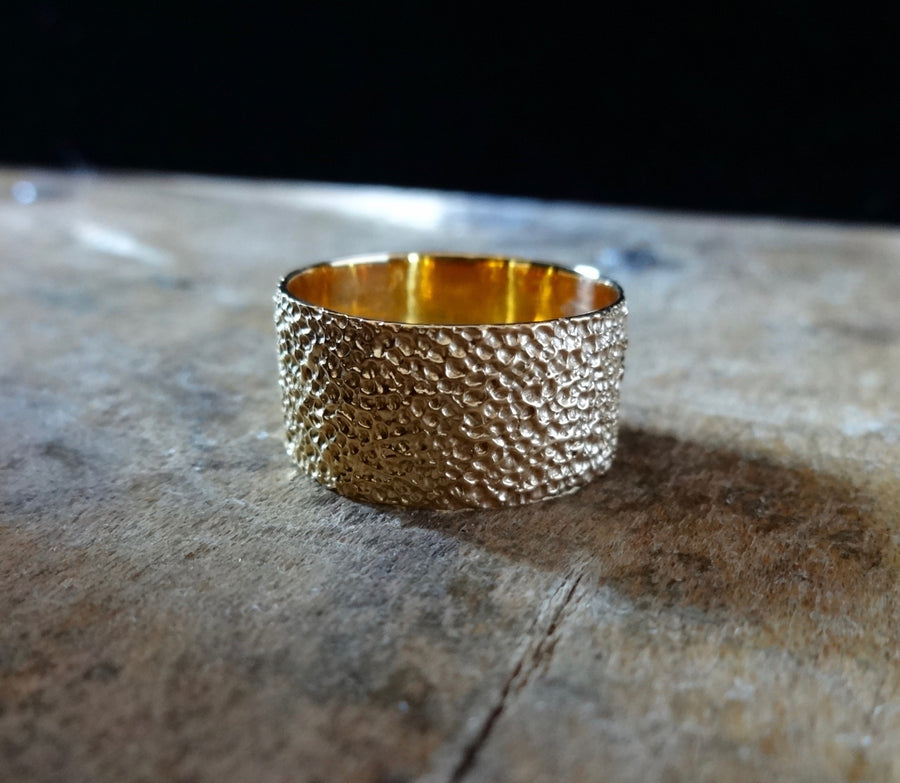 Simple elegant broad ring bands hand textured to emulate the dappled light naturally found in nature handmade in NYC by designer Jayne Moore model Jayne Moore from recycled refined metals in 18kt gold a light classic timeless wedding band for him or for her 