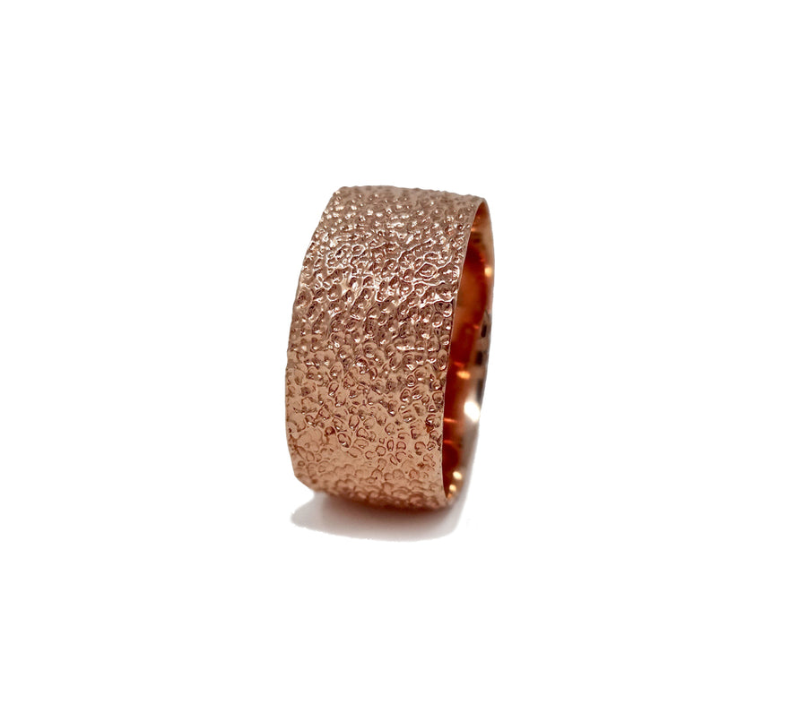 Simple elegant broad ring bands hand textured to emulate the dappled light naturally found in nature handmade in NYC by designer Jayne Moore model Jayne Moore from recycled refined metals in 18kt gold a light classic timeless wedding band for him or for her 