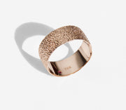 Simple elegant broad ring bands hand textured to emulate the dappled light naturally found in nature handmade in NYC by designer Jayne Moore model Jayne Moore from recycled refined metals in 18kt gold a light classic timeless wedding band for him or for her 