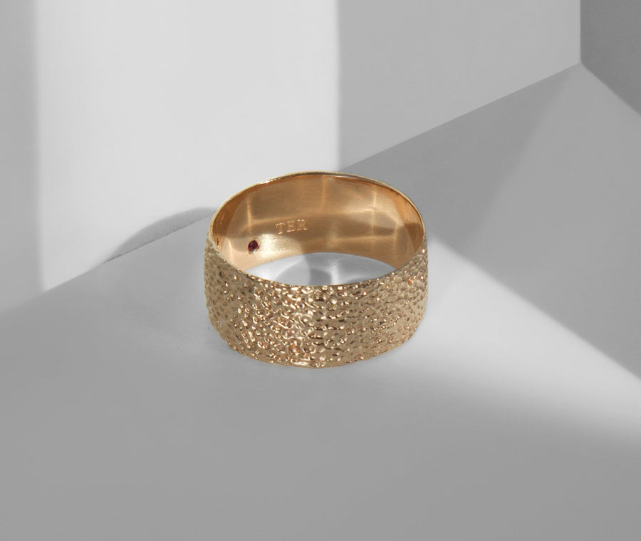 Simple elegant broad ring bands hand textured to emulate the dappled light naturally found in nature handmade in NYC by designer Jayne Moore model Jayne Moore from recycled refined metals in 18kt gold a light classic timeless wedding band for him or for her 