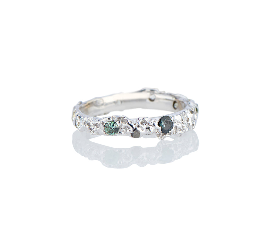Jayne Moore Model makes unique jewelry all handmade in New York city from recycled metals using certified conflict free diamonds in unconventional ring settings this ring is made from sugar and sand and is asymmetrical and highly textured creating a contemporary wedding band or every day ring for the alternative bride or groom stackable rings made in nyc sapphires rebel set unconventional set sapphires teal sapphires blue sapphires castnotset cast not set cast in place one of a kind jewelry 