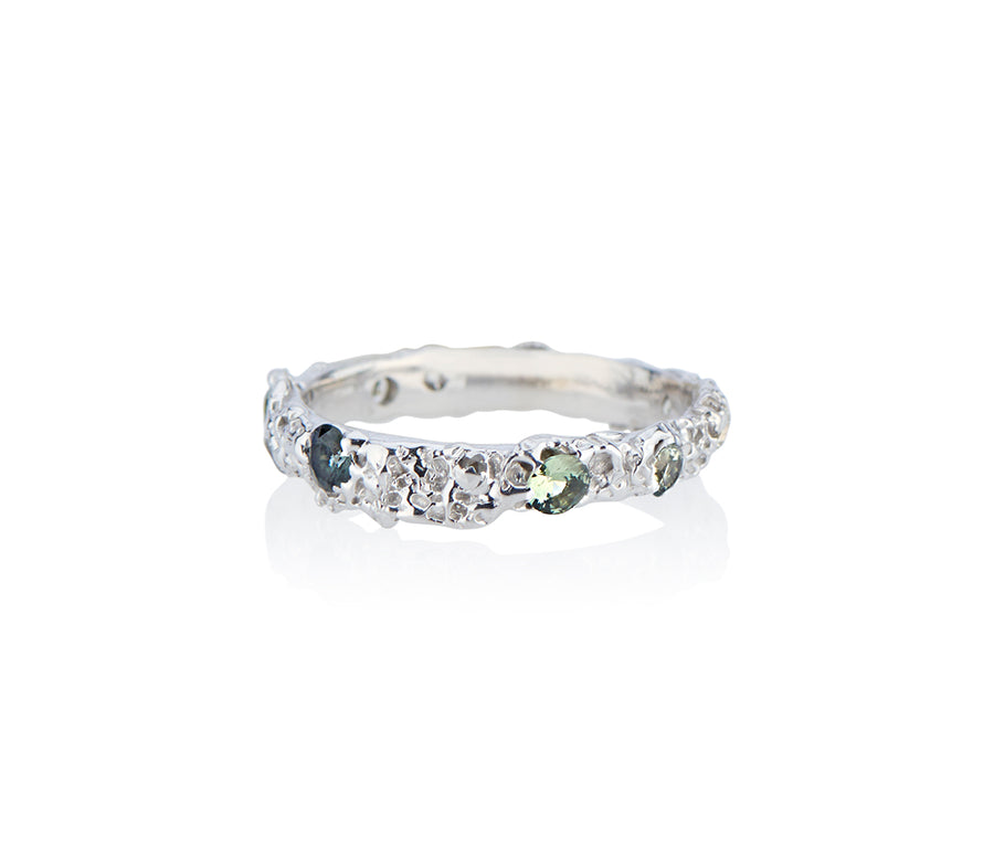 Jayne Moore Model makes unique jewelry all handmade in New York city from recycled metals using certified conflict free diamonds in unconventional ring settings this ring is made from sugar and sand and is asymmetrical and highly textured creating a contemporary wedding band or every day ring for the alternative bride or groom stackable rings made in nyc sapphires rebel set unconventional set sapphires teal sapphires blue sapphires castnotset cast not set cast in place one of a kind jewelry 